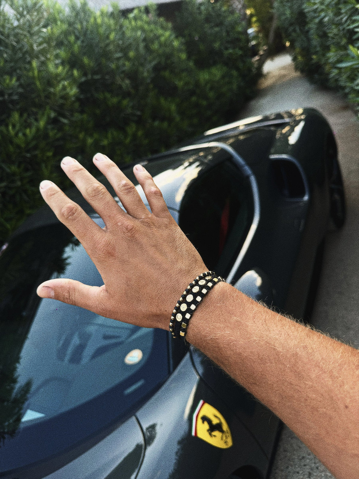 Zwarte Caviar armband op een zwarte sportwagen